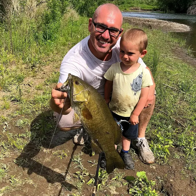 J.C. and his youngest son with a smallmouth bass
